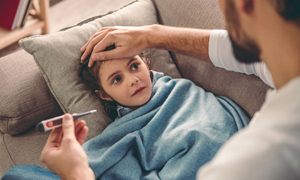 father taking sick daughters temperature